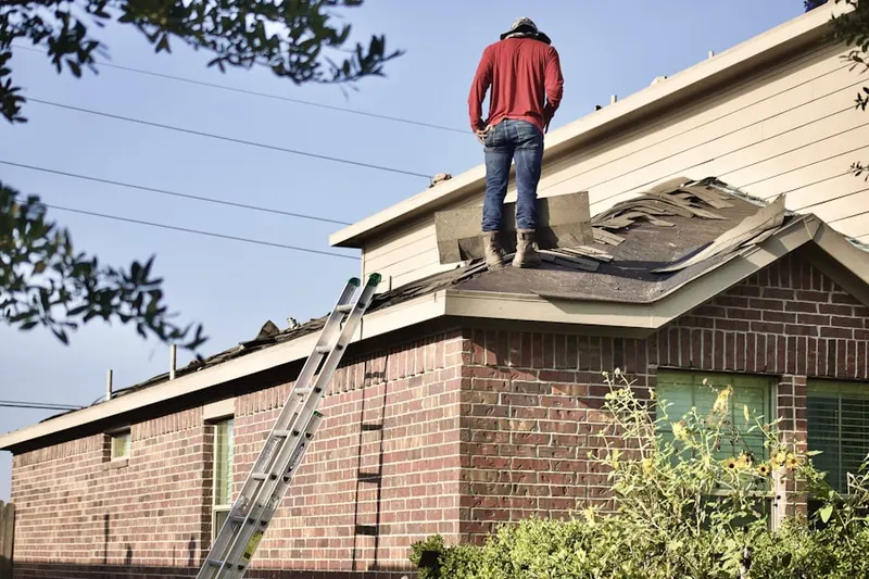 Professional roofer working on a residential roof in Ludington